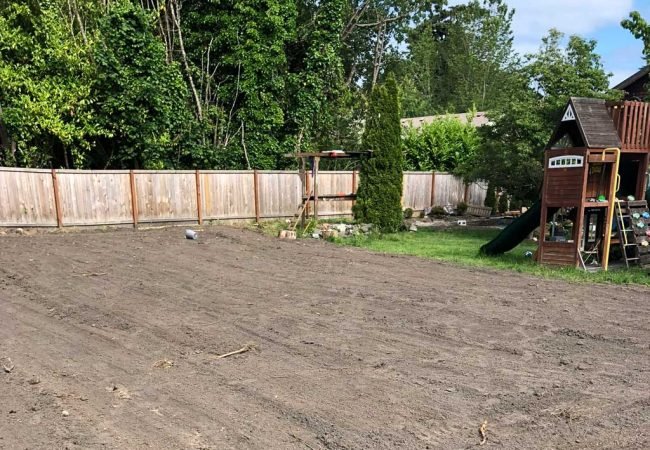 Freshly graded residential backyard prepared for new lawn installation or landscaping.